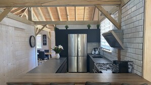 Una cocina moderna con una isla central, electrodomésticos de acero inoxidable y un área de comedor con sillas.