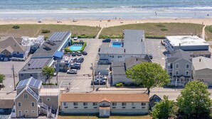 An aerial view of a coastal town with buildings, a beach, and a parking lot. - Sands Townhouses (Old Orchard Beach)