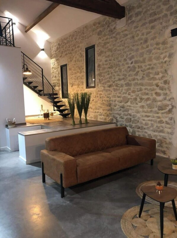 Relax in this stylish space with a sofa and a staircase leading to an upper level.