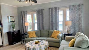 A living room with a sofa, a round coffee table, a side table, and a lamp. - Surfs Up,  Second Row, Upper Level Unit (Folly Beach)