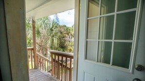 A wooden deck with a glass door leading to a covered porch. - Surfs Up,  Second Row, Upper Level Unit (Folly Beach)