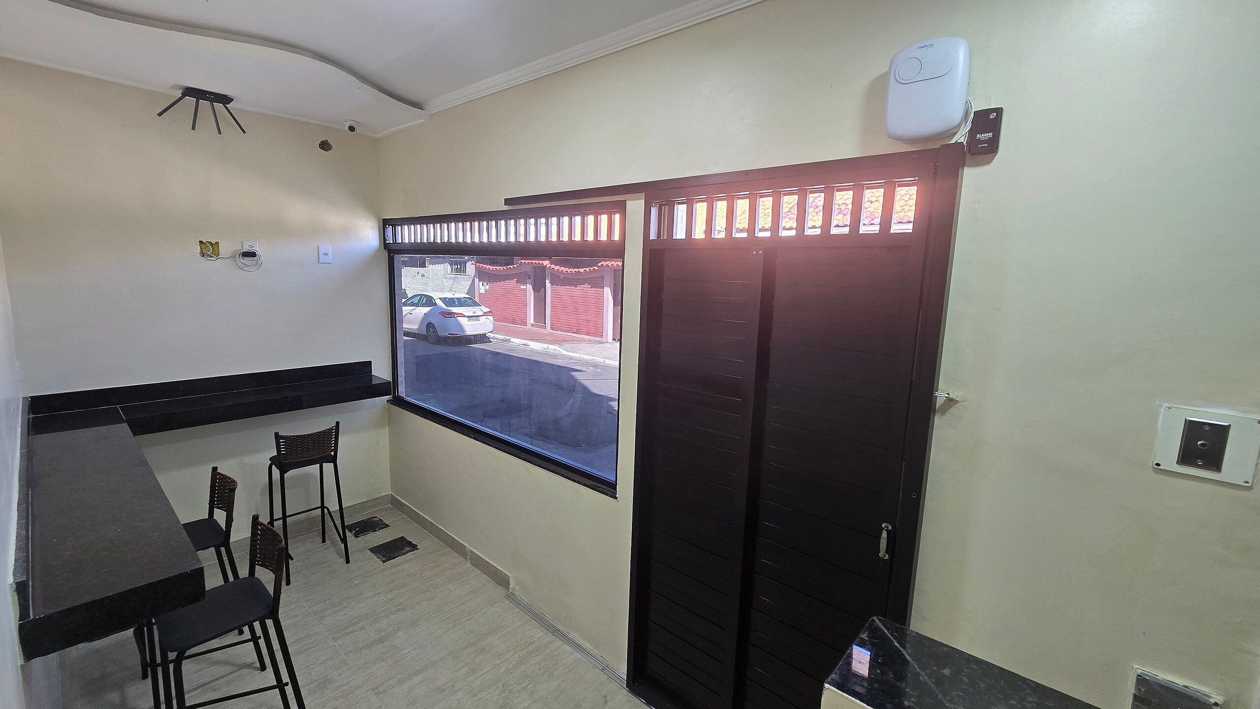 A small room with a window, a door, and a table with chairs.