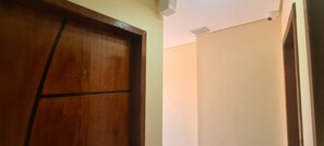 A wooden door with a number '1' and a plain wall with a ceiling vent.