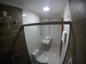 A modern bathroom with a glass shower enclosure, a white toilet, and a sink. - Recanto Del Mare (Arraial do Cabo)