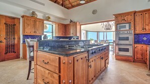 A spacious kitchen with wooden cabinets, a large island, and modern appliances.