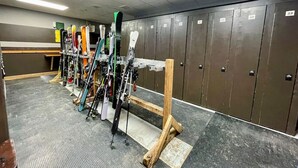 A ski rental area with multiple ski racks and lockers along the wall. - Apex Mountain ~ Hillside Hideout ~ Apex Mountain Inn (Apex Mountain Resort)