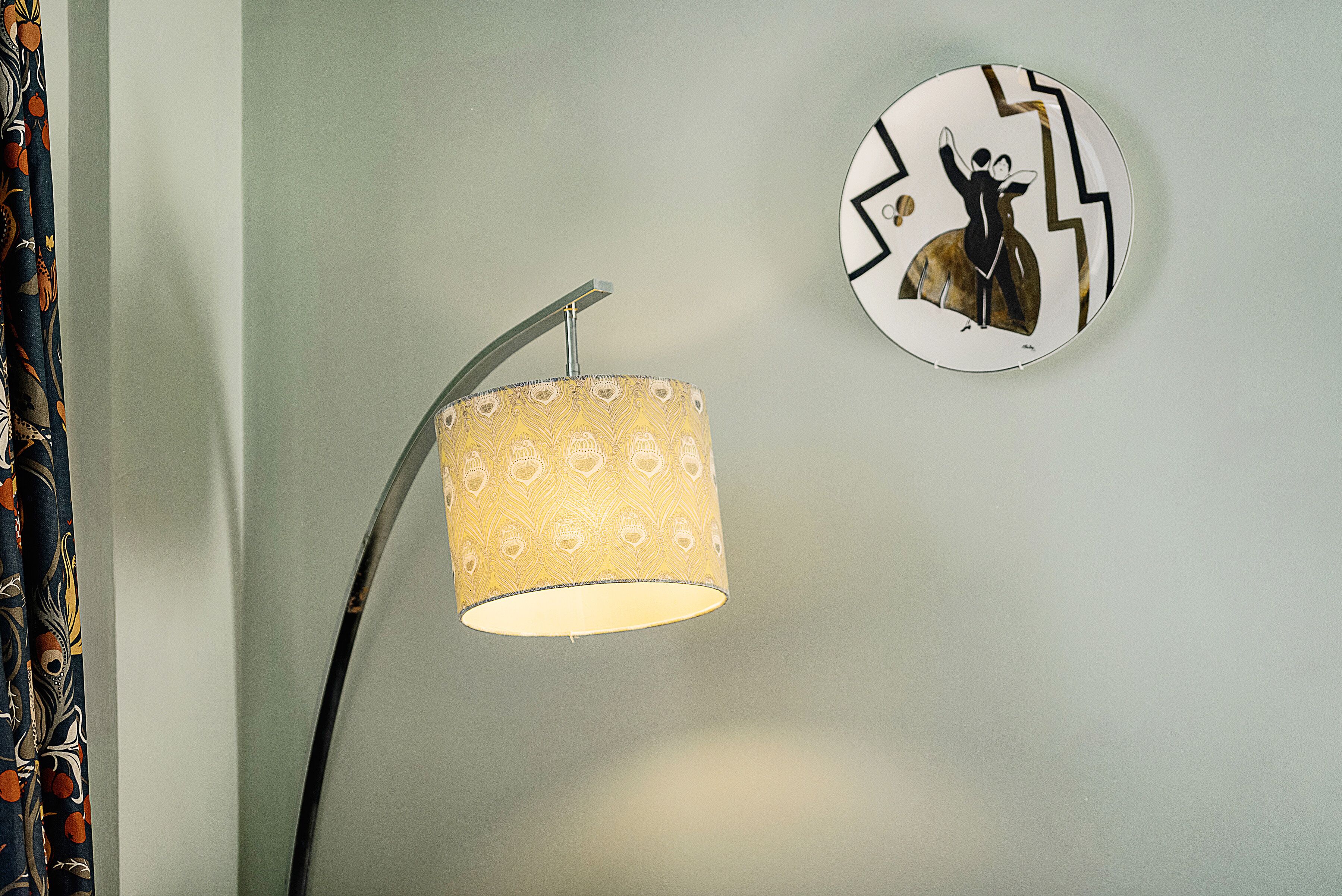 Une lampe avec un abat-jour à motifs et une horloge murale au design géométrique.