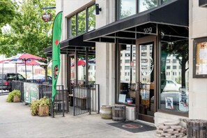 Welcome to 309, a modern building with a charming entrance featuring a glass door and potted plants.