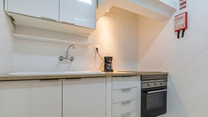 A kitchen with a sink, a coffee maker, and a stove.