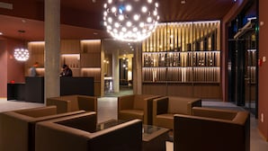 Un vestíbulo con muebles modernos, un mostrador de recepción y una escalera.