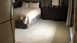 A bedroom with a bed, dresser, and a refrigerator. - Oakes Oramel Inn (Belfast)