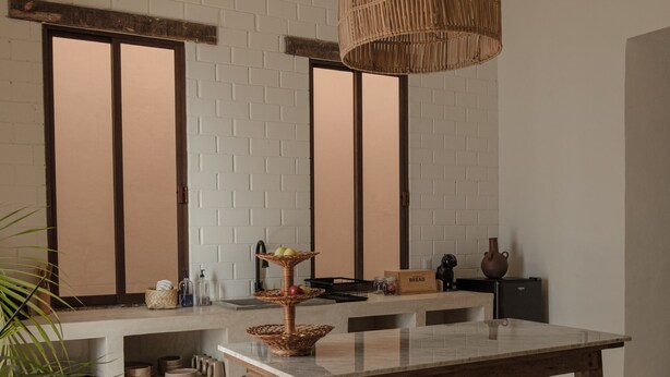 Una cocina moderna con una isla grande, iluminación colgante y un estilo rústico.