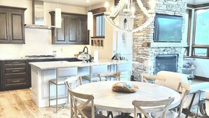 A spacious kitchen with a large island, wooden cabinets, and a stone accent wall.