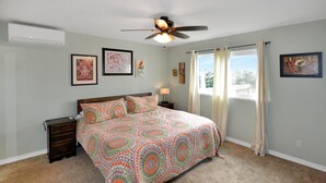 A bedroom with a bed, a nightstand, a ceiling fan, and a window with curtains. - Atargatis "the first mermaid"; an updated & spacious home, close to everything! (Brookings)