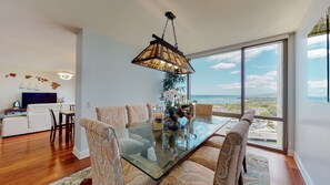 Enjoy meals in this stylish dining area with a glass-top table and comfortable seating, offering a view of the ocean and surrounding landscape.