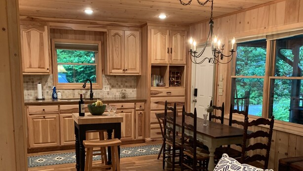 Interior de madera acogedor con comedor, cocina y zona de estar.