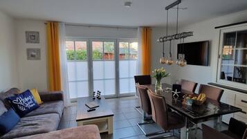 Un salon moderne avec un canapé, une table basse et une table à manger.