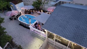 Una piscina con solarium, circondata da ombrelloni e mobili da esterno.
