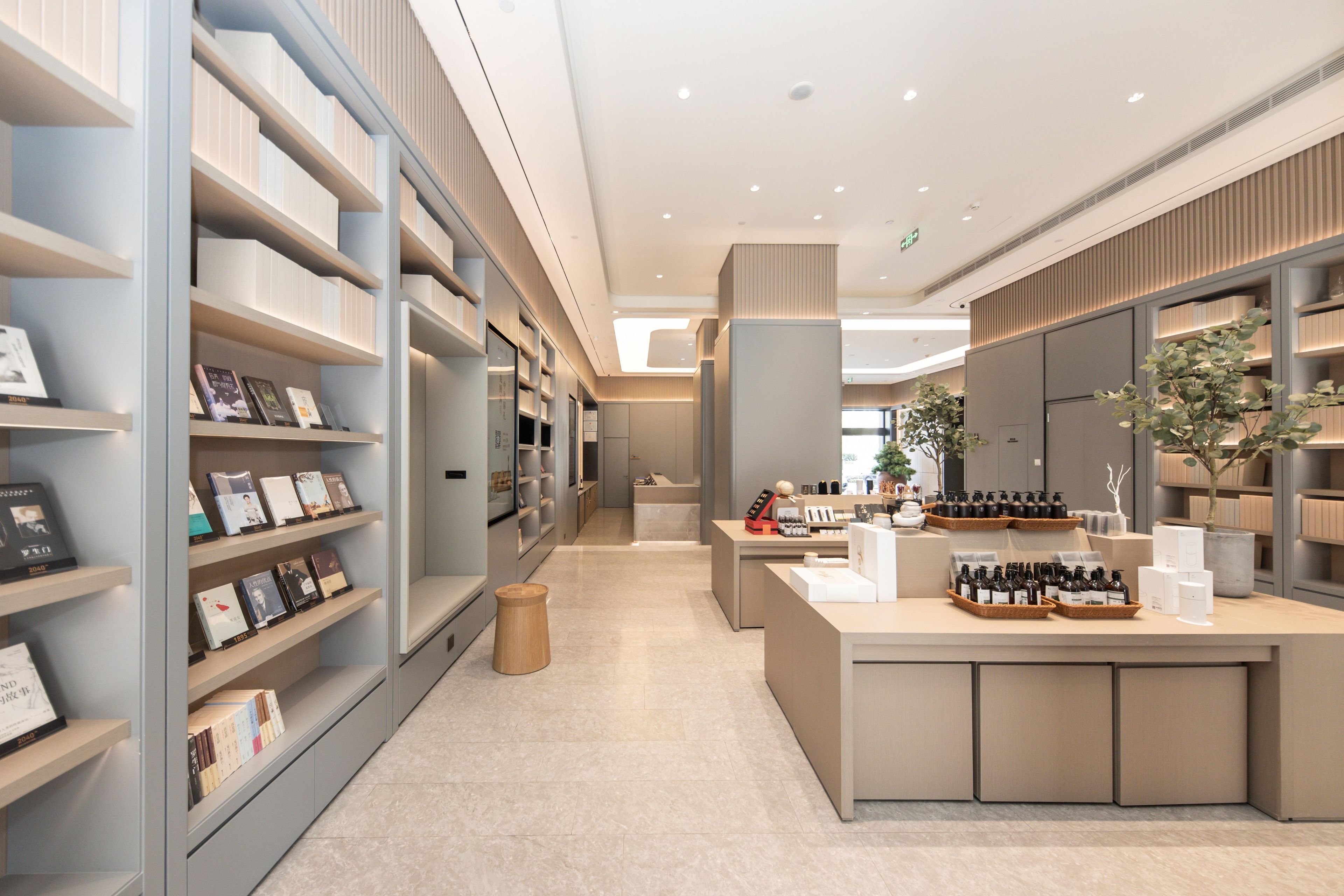 A modern, well-lit bookstore with shelves of books and a central counter displaying various items.