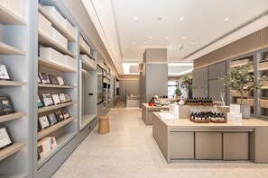 A modern, well-lit bookstore with shelves of books and a central counter displaying various items.