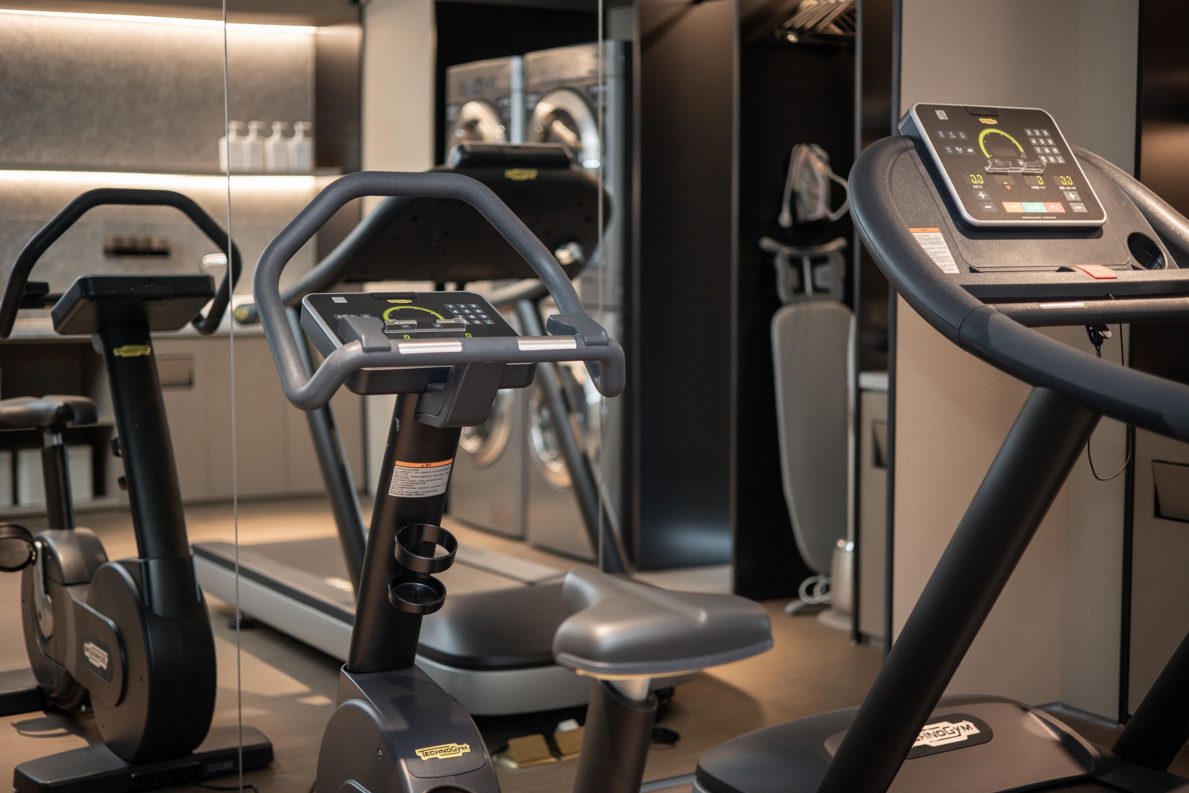 A gym with exercise equipment including treadmills and an elliptical machine.