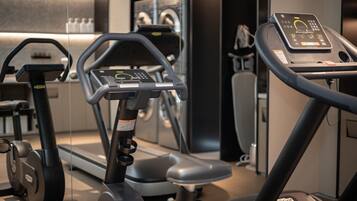 A gym with exercise equipment including treadmills and an elliptical machine.