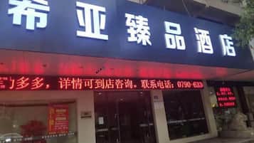 A hotel sign with Chinese characters and a contact number.