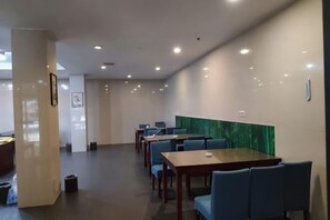 Quarto de hotel com uma cama grande, uma mesa de cabeceira, uma janela e uma televisão fixada na parede.