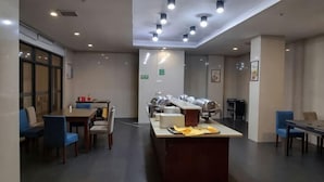 Un comedor moderno con una isla central, diversas opciones de asientos y un ambiente limpio y bien iluminado.