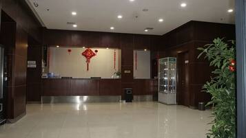 A reception area with a counter, a glass display case, and a potted plant.