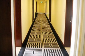 A hallway with a patterned floor leading to a door at the end. - Xiya Zhenpin Hotel (Xinyu)
