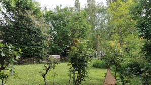 A garden with a stone bench, lush greenery, and a variety of plants. - 2* gîte on the ground floor of an old pottery in the center of Dieulefit (Dieulefit)