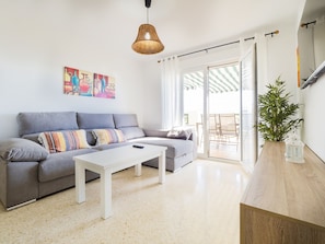 Relax in this stylish living room with a sofa, coffee table, and sliding glass door leading to an outdoor area.