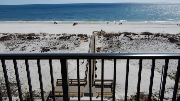 A beach view from a balcony with a wooden deck and a railing. - Beachfront condo at Island Winds West in Gulf Shores (Gulf Shores)