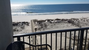 A beach view from a balcony with a wooden deck and metal railing. - Beachfront condo at Island Winds West in Gulf Shores (Gulf Shores)