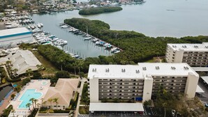Un port de plaisance avec des bateaux amarrés, une piscine et un parking.