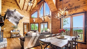 A log cabin interior with a dining area, a sofa, and a fireplace. - Family-Friendly Blue Ridge Log Cabin w Stunning Views-Free Flexible Check In-Out (Blue Ridge)