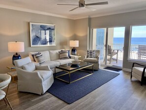 Enjoy ocean views from the large window in this coastal retreat, featuring a sofa set and coffee table.