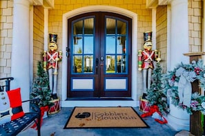Entrada dupla com tapete de boas-vindas, estátuas de duendes e decorações de Natal.