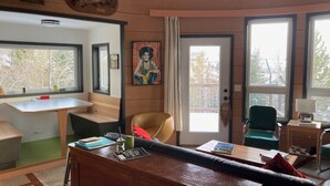 Una habitació amb escriptori de fusta, cadira, llit i finestra.