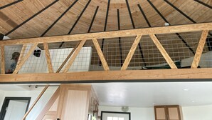 Una estança d'alt sostre amb bigues de fusta i una estructura de sostre en forma de graella.