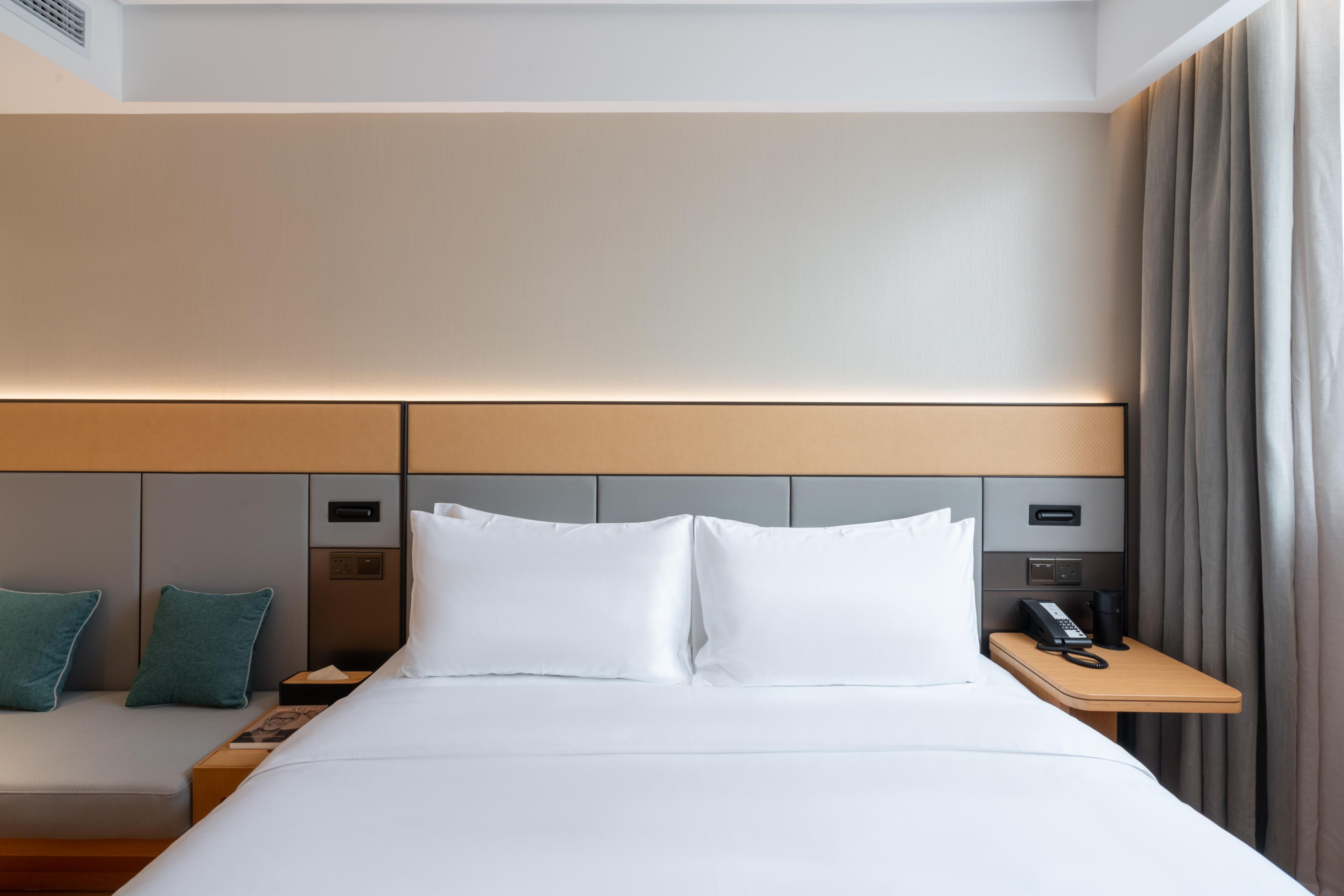 Una habitación de hotel con cama, mesita de noche y teléfono.