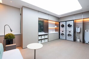 Une cuisine moderne dotée d’appareils électroménagers intégrés, d’une petite table et d’une plante en pot.