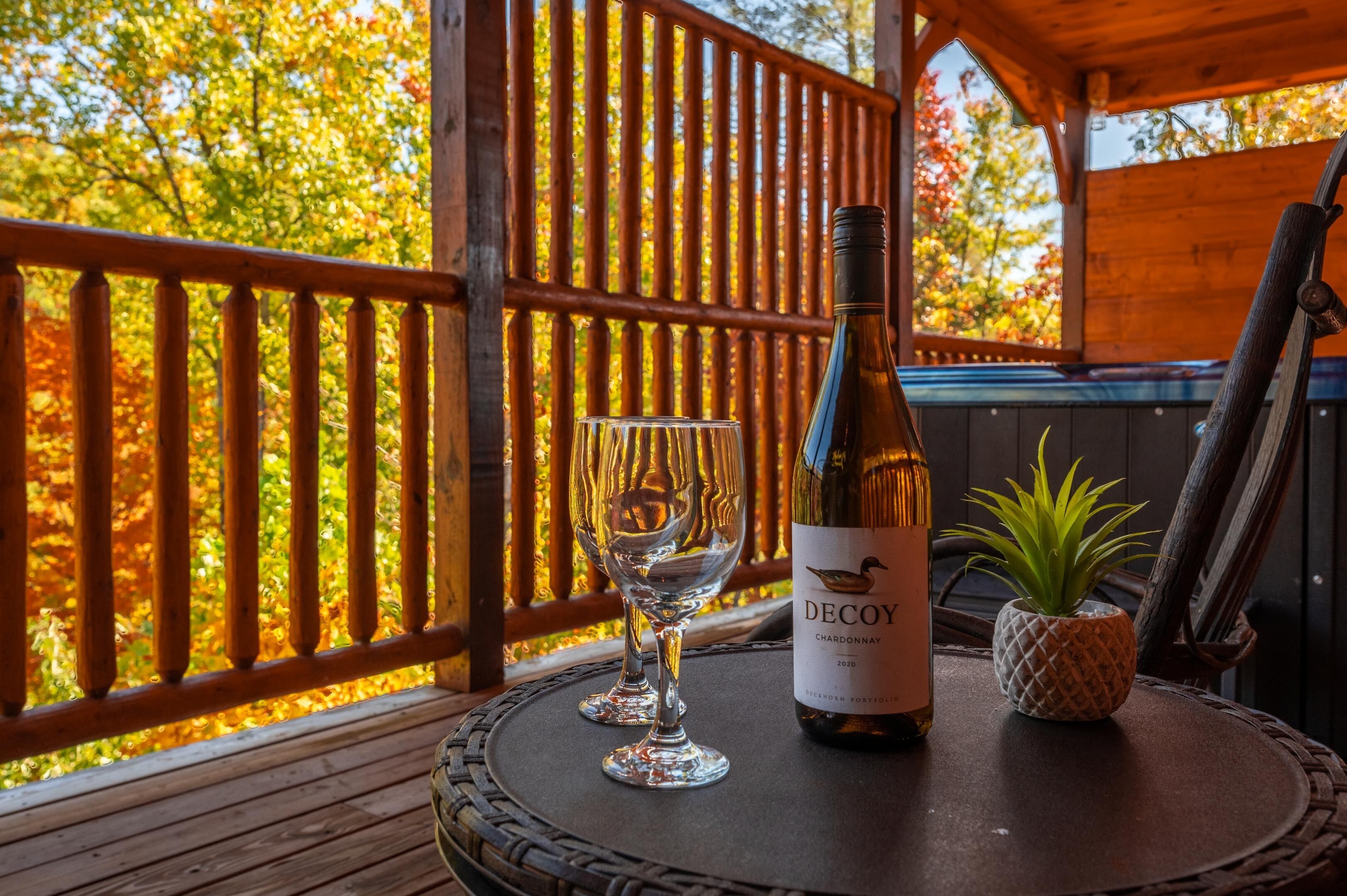 Une bouteille de Chardonnay Decoy sur une table, avec deux verres et une petite plante.