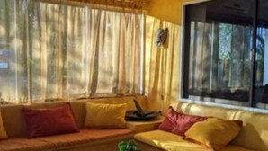 A living room with a sofa, a glass coffee table, and a ceiling fan. - Pelicano Loft House (Esterillos Este)