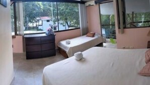 A hotel room with a large bed, a smaller bed, a window seat, and a view of the outdoors. - Pelicano Loft House (Esterillos Este)
