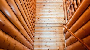 Un escalier en bois à l’intérieur d’une cabane en rondins.