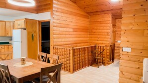 Un intérieur en bois comprenant un coin repas, une cuisine et un petit espace salon.