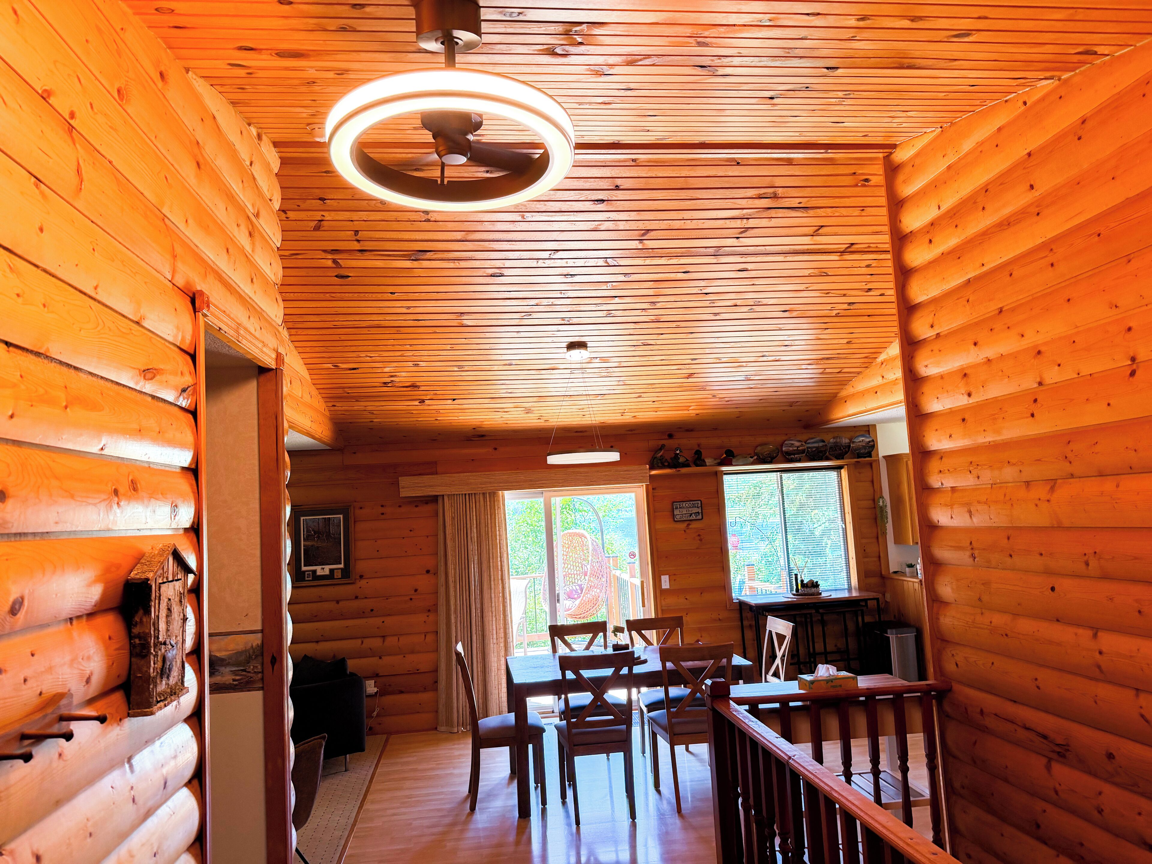 A log cabin interior with a dining area, a kitchen, and a living space.