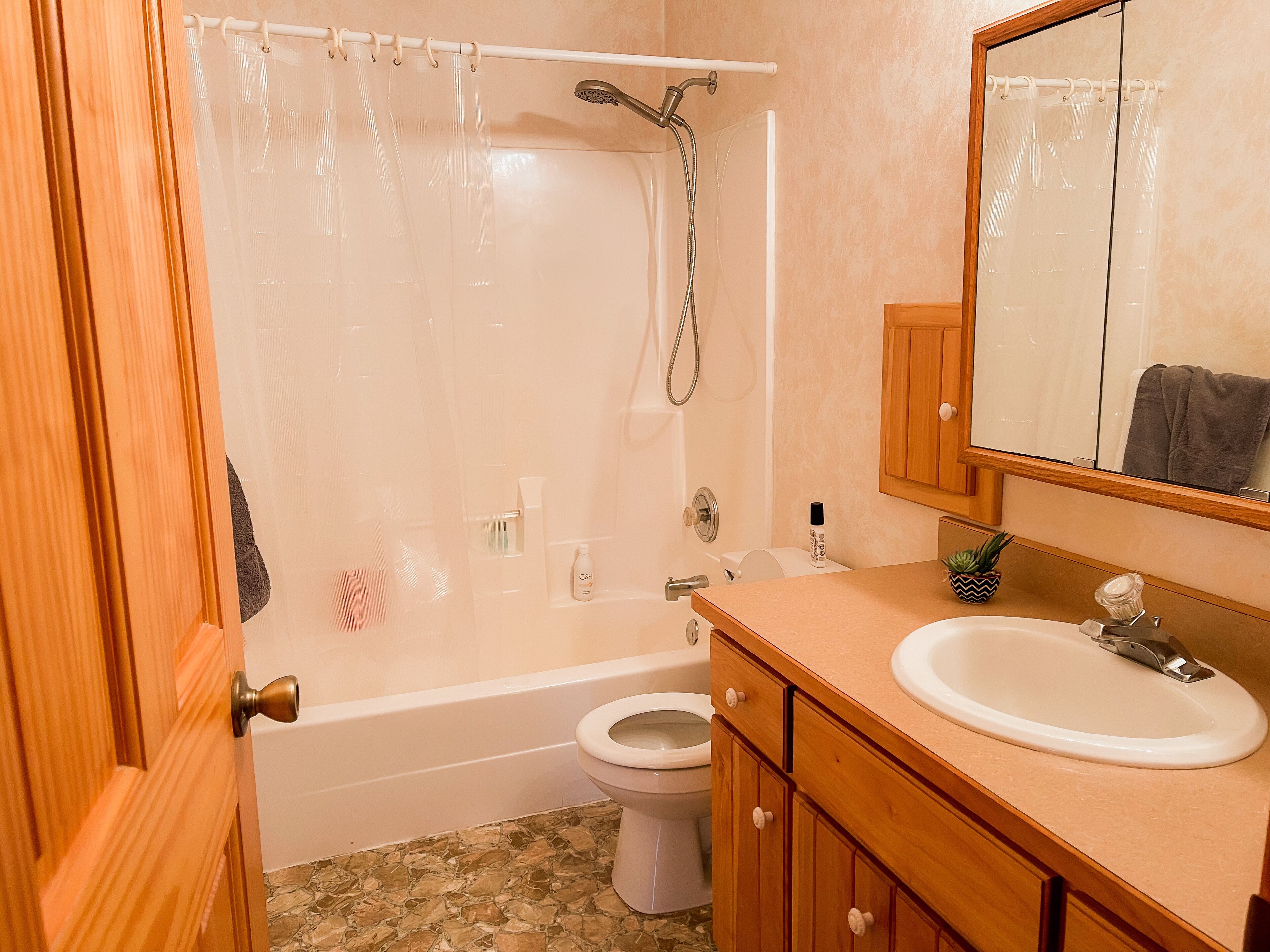 Un baño con bañera, inodoro, lavabo y espejo.